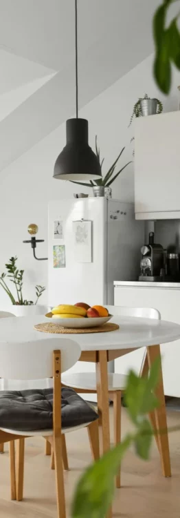 Coin repas dans une cuisine lumineuse avec table ronde et corbeille de fruits