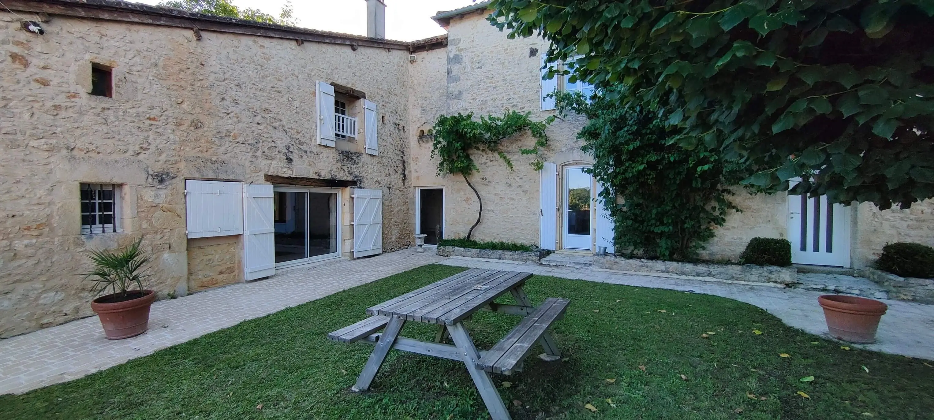 Cour intérieure en pierre du Clos Lagrange avec table de pique-nique en bois
