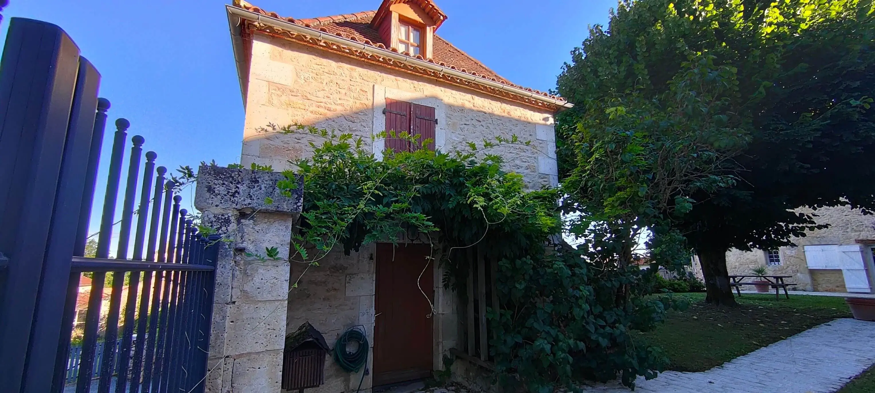 Pigeonnier restauré en pierre habillé d'une glycine au Clos Lagrange