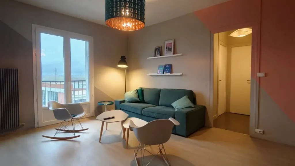 Salon de l'Appartement Cosy Charente à Angoulême avec canapé bleu et balconnet vue dégagée